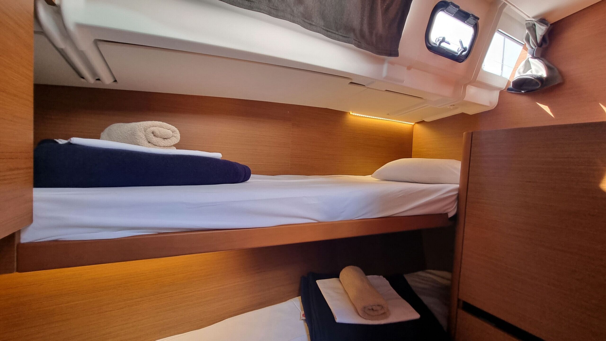 Una cabaña pequeña con una cama litera, un ventanal y un armario para guardar cosas.