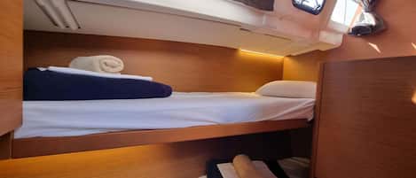 A compact cabin with a bunk bed, a small window, and a storage cabinet.