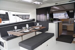 A modern RV interior with a dining area, seating, and a kitchenette. - Sun-Kissed Sailing Adventure in the Ionian Islands, Lefkada (Lefkada)