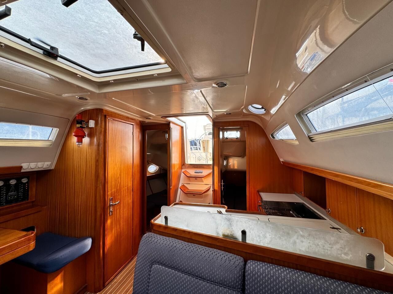 Een compact interieur met een centraal geplaatst bed, een kleine kitchenette en een eethoek.