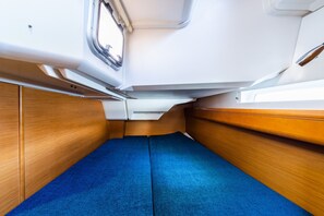 A compact interior with a blue carpet, wooden paneling, and a window. - Sun-Kissed Sailing Adventure in the Ionian Islands, Lefkada (Lefkada)