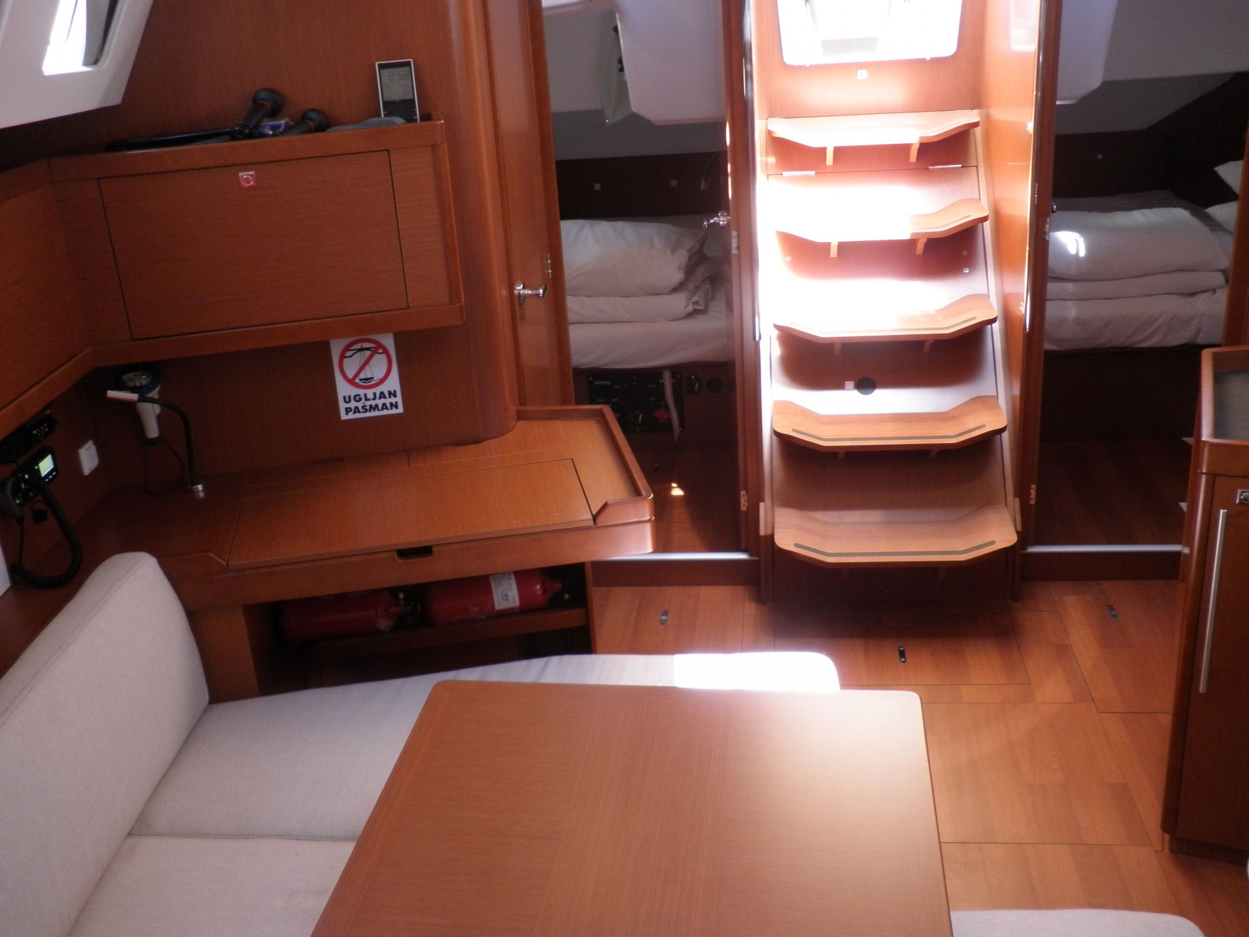 A compact RV interior with a bed, a seating area, and a storage cabinet.