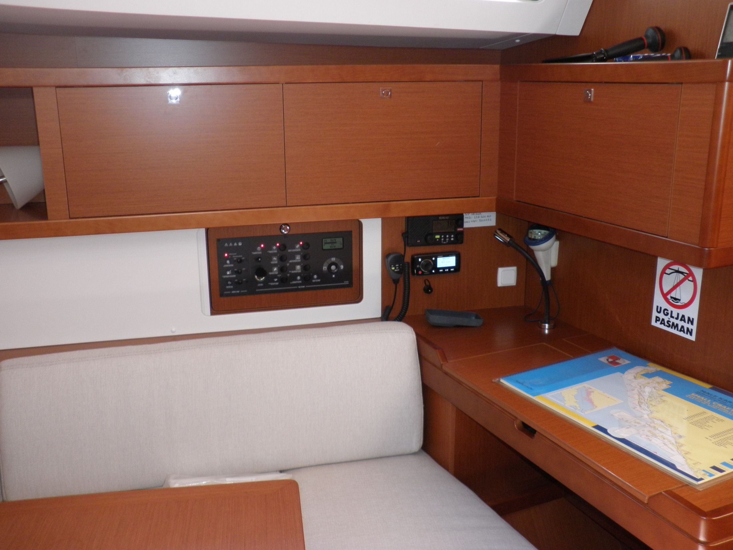 A cabin with wooden cabinetry, a control panel, a map, and a no-smoking sign.