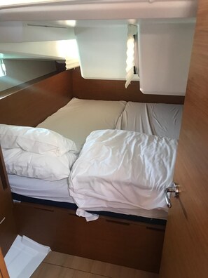 Ein kleines Zimmer mit einem Bett, einem Tisch und einer Tür.