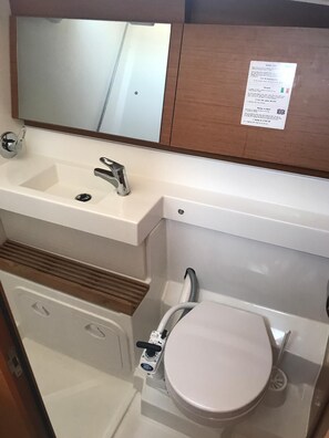 Ein Badezimmer mit Waschbecken, Spiegel und Toilette.