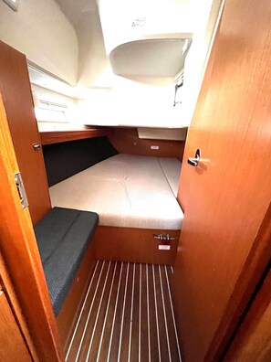 A compact interior with a bunk bed, a small bench, and a storage compartment. - Sun-Kissed Sailing Adventure in Zadar, Croatia (Bibinje)