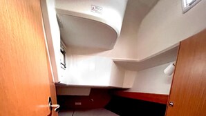 A compact interior with a bunk bed, a small window, and a door. - Sun-Kissed Sailing Adventure in Zadar, Croatia (Bibinje)
