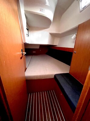 A compact interior with a bunk bed, a small window, and a door. - Sun-Kissed Sailing Adventure in Zadar, Croatia (Bibinje)