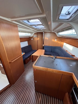 A compact, well-lit interior with a kitchenette, seating area, and skylights. - Sun-Kissed Sailing Adventure in Zadar, Croatia (Bibinje)
