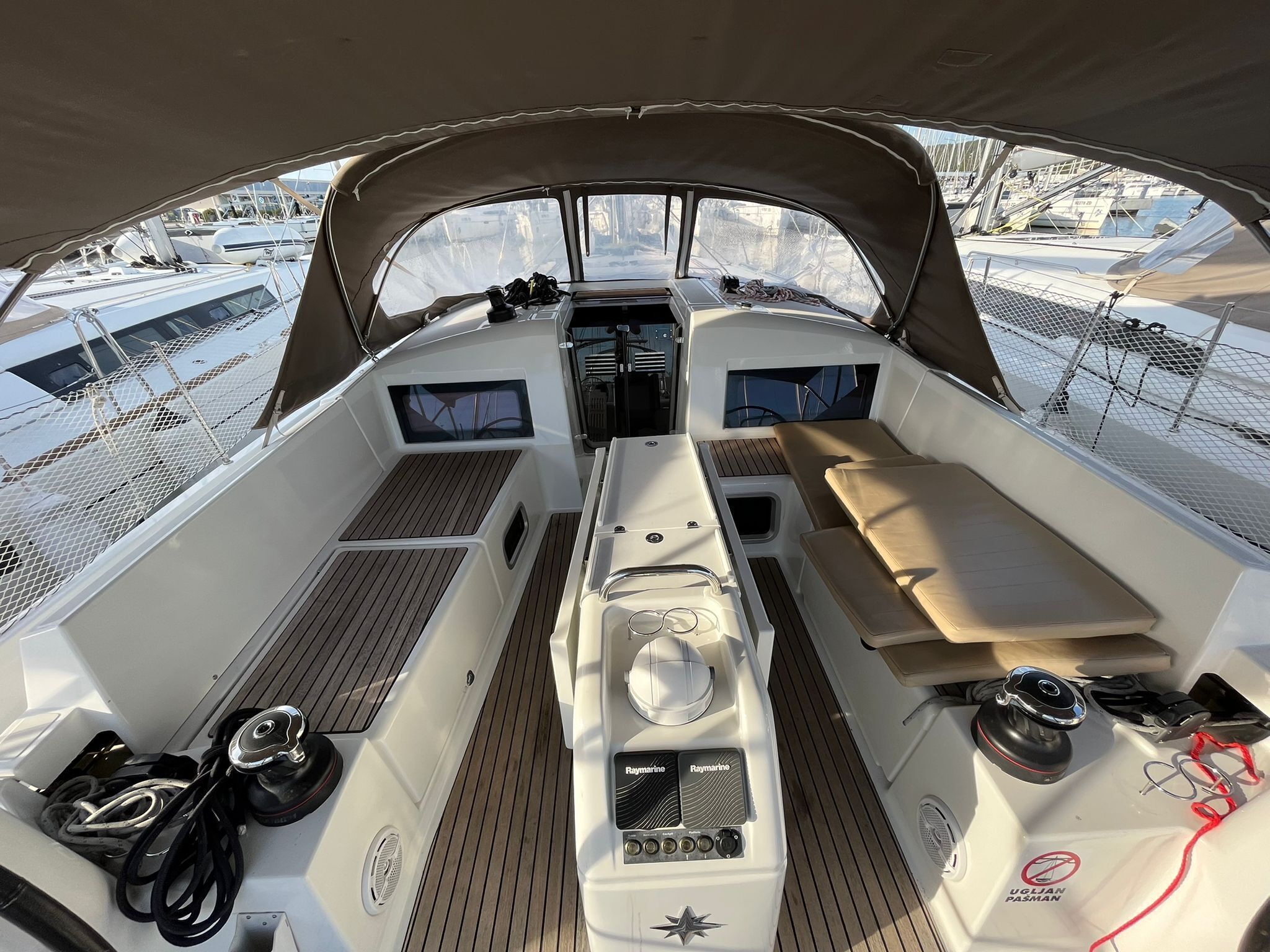 A boat's interior with a steering wheel, control panel, and seating area.