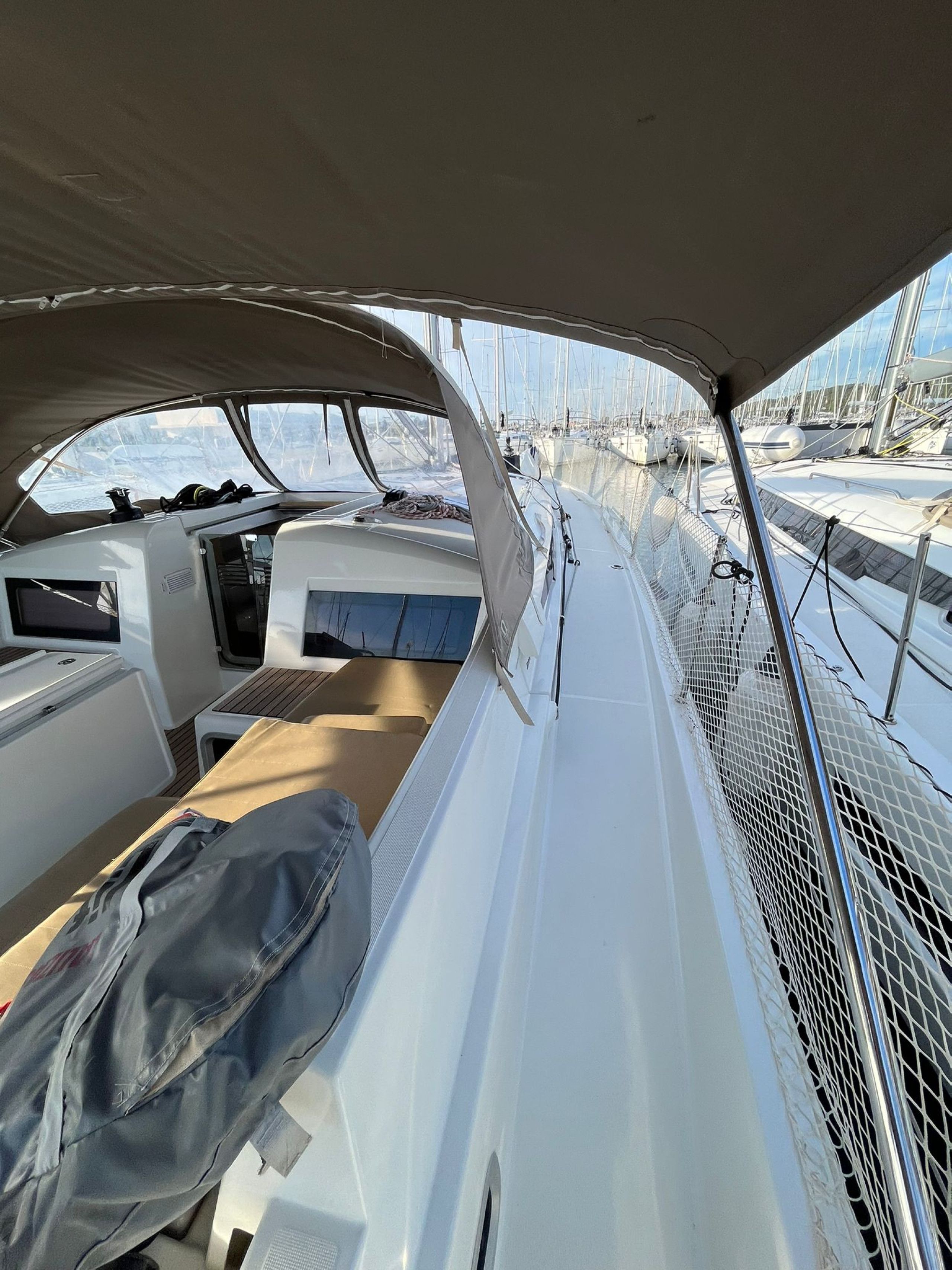 L'intérieur d'un bateau, avec un coin salon, une petite table et un garde-corps en filet.