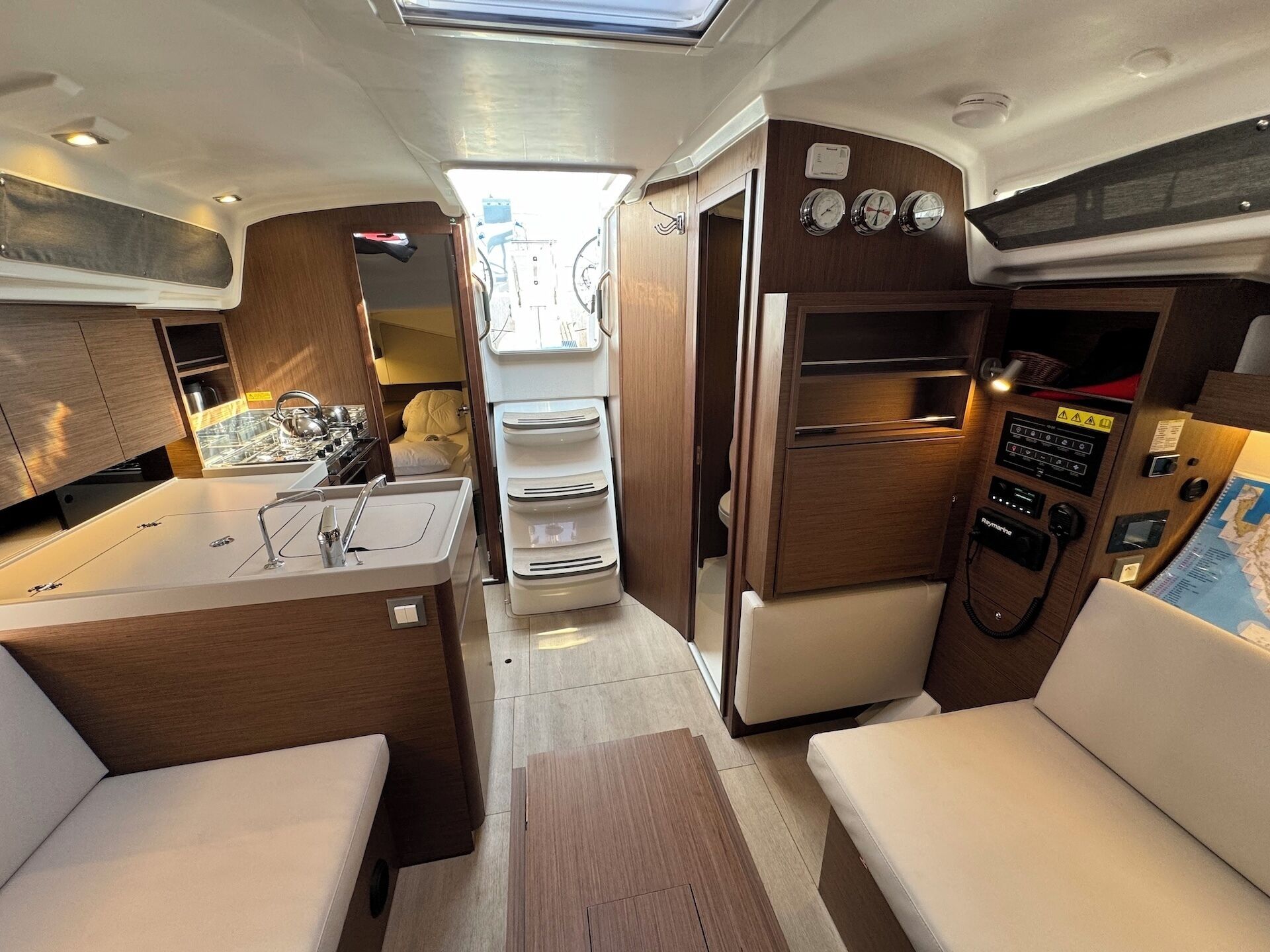 A compact galley with a sink, stove, and storage cabinets.