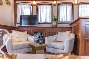 A cozy seating area with two armchairs, a small table, a television, and a potted plant. - Sun-Kissed Sailing Adventure in Split, Croatia (Split)