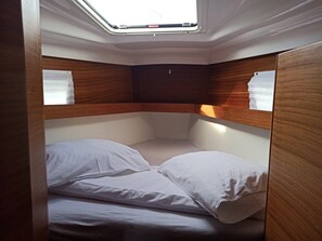 A compact, well-lit cabin with a bunk bed, wooden paneling, and a skylight. - Sun-Kissed Sailing Adventure in Northern Croatia (Punat)