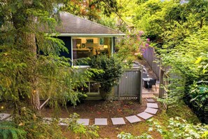 A house with a visible kitchen area, a fenced backyard, and a garden path. - Lake City 5BR Retreat, Hot Tub, 2 Fire Pits, EV, Sleeps 10 (Seattle)