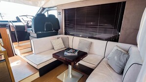A modern interior with a sofa, a coffee table, and a window with blinds. - Sun-Kissed Sailing Adventure in Zadar, Croatia (Bibinje)