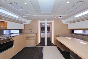 Interior compacto de una caravana con kitchenette, zona de comedor y litera.