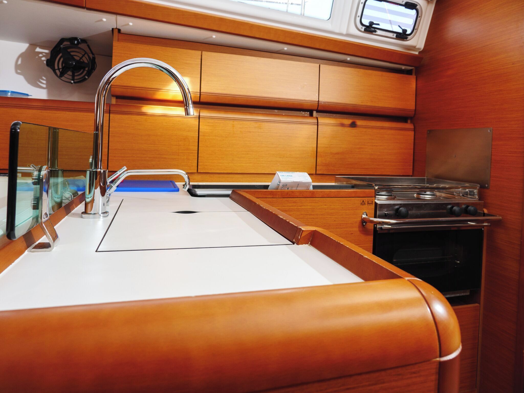 Una cocina con campana extractora de acero inoxidable, un lavamanos doble y armarios de madera.