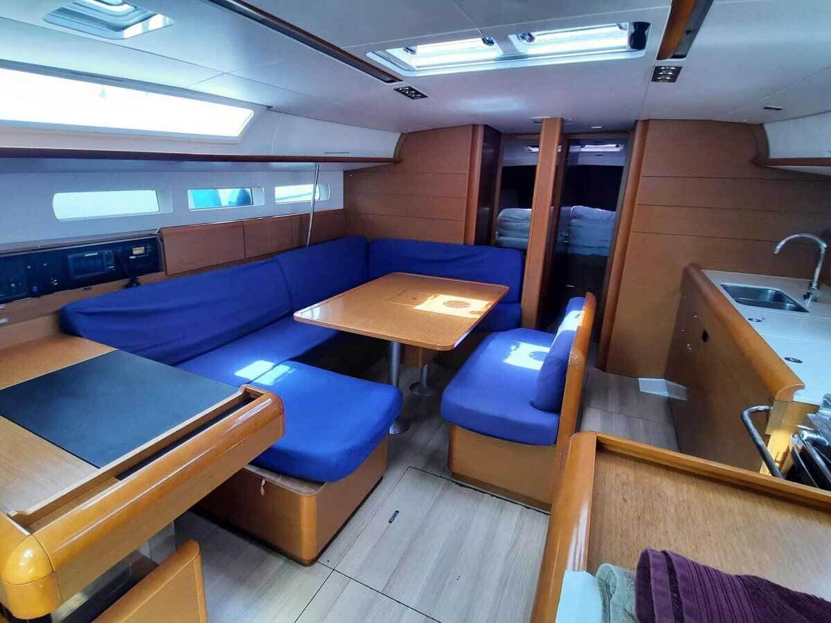 Een compact interieur met een zithoek, een kleine tafel en een kitchenette.