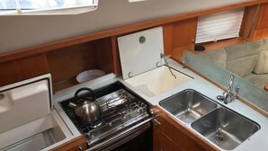 Una piccola cucina componibile con fornello, forno e due lavandini.