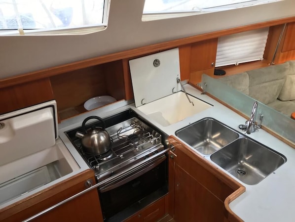 A compact galley with a stove, oven, and two sinks.