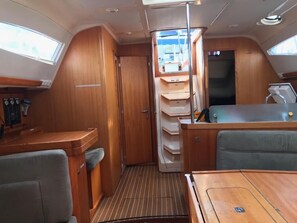 A compact interior with a dining area, a small kitchen, and a storage cabinet.