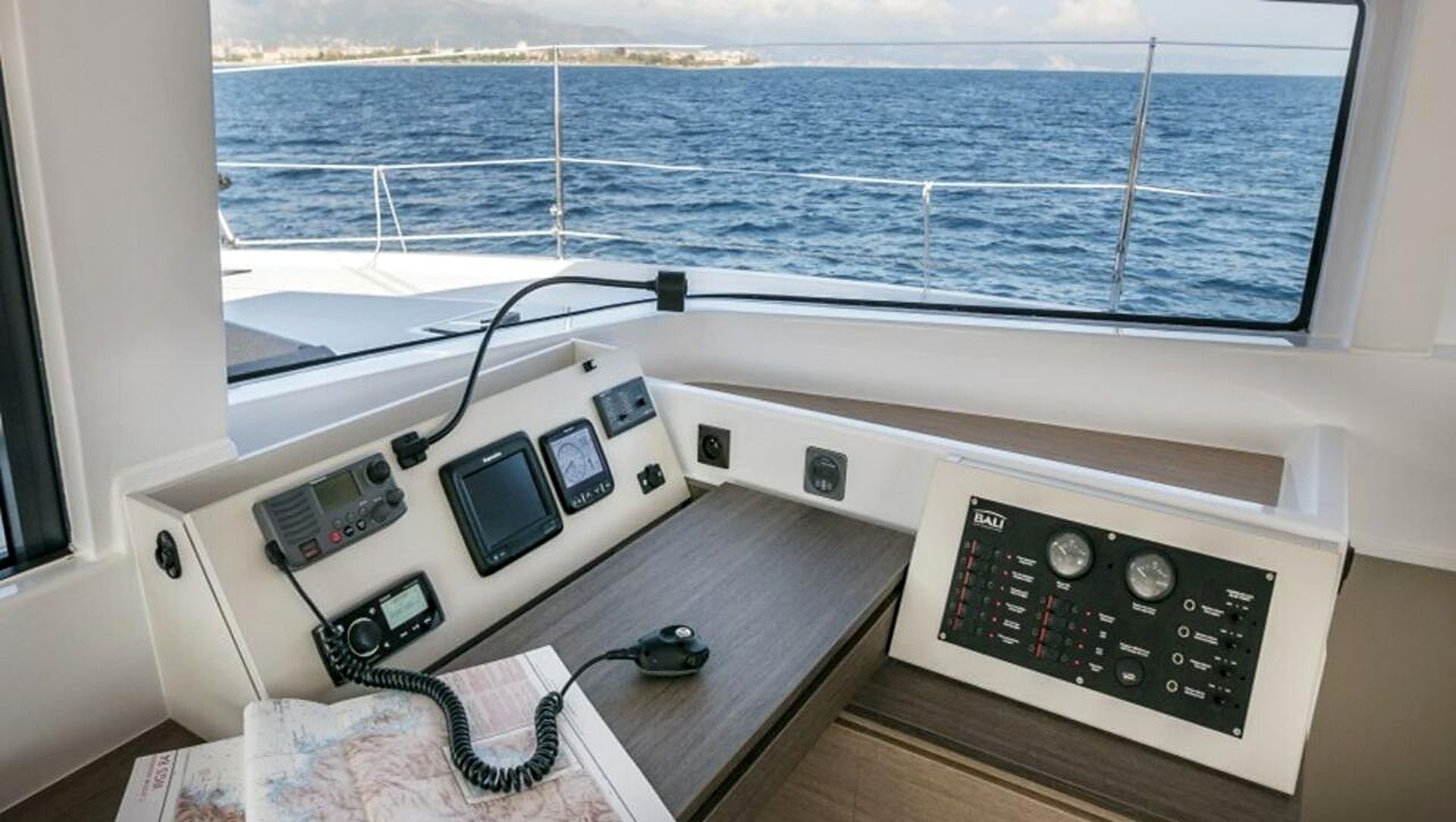 Styrestation på en båd med kort, kommunikationsudstyr og navigationsinstrumenter.