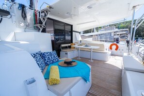 A yacht's deck with a seating area, a table, and a life preserver. - Sun-Kissed Sailing Adventure in Istria, Croatia (Pula)