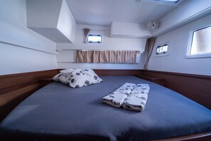 A compact cabin with a single bed, a small window, and a fan. - Sun-Kissed Sailing Adventure in Istria, Croatia (Pula)
