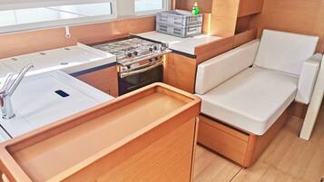 Une cuisine de taille réduite, équipée d’une cuisinière, d’un évier et de placards de rangement.