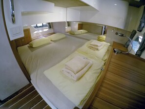 Ein Zimmer mit einem Bett, einem Nachttisch, einem Spiegel und einem Fenster.