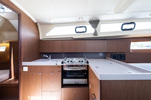 A compact galley with a stove, oven, and a small sink. - Sun-Kissed Sailing Adventure in the Ionian Islands, Lefkada (Lefkada)