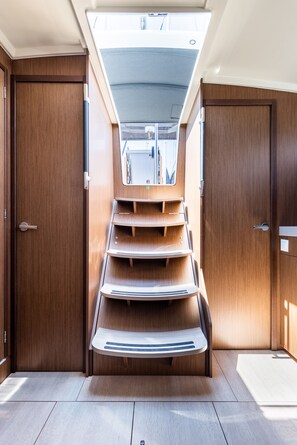 A compact interior with a central staircase, wooden walls, and a skylight. - Sun-Kissed Sailing Adventure in the Ionian Islands, Lefkada (Lefkada)