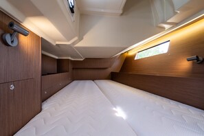 A compact, well-lit interior with a bed, wooden paneling, and a small window. - Sun-Kissed Sailing Adventure in the Ionian Islands, Lefkada (Lefkada)