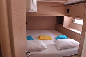 Ein kleines Schlafzimmer mit Etagenbett, kleinem Fenster und eingebauten Stauraumschränken.