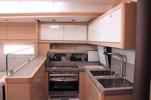 A compact kitchen with a stove, oven, and two sinks. - Sun-Kissed Sailing Adventure in the Ionian Islands, Lefkada (Lefkada)