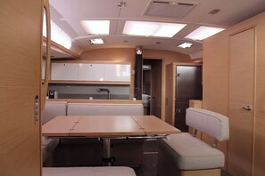 A compact RV interior with a dining area, kitchenette, and a sleeping berth. - Sun-Kissed Sailing Adventure in the Ionian Islands, Lefkada (Lefkada)