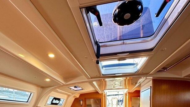 Interior de un yate con zona de comedor, panel de control y cocina.