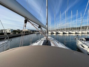 Ein Yachthafen mit mehreren Segelbooten, ein klarer Himmel und ein Gebäude im Hintergrund.