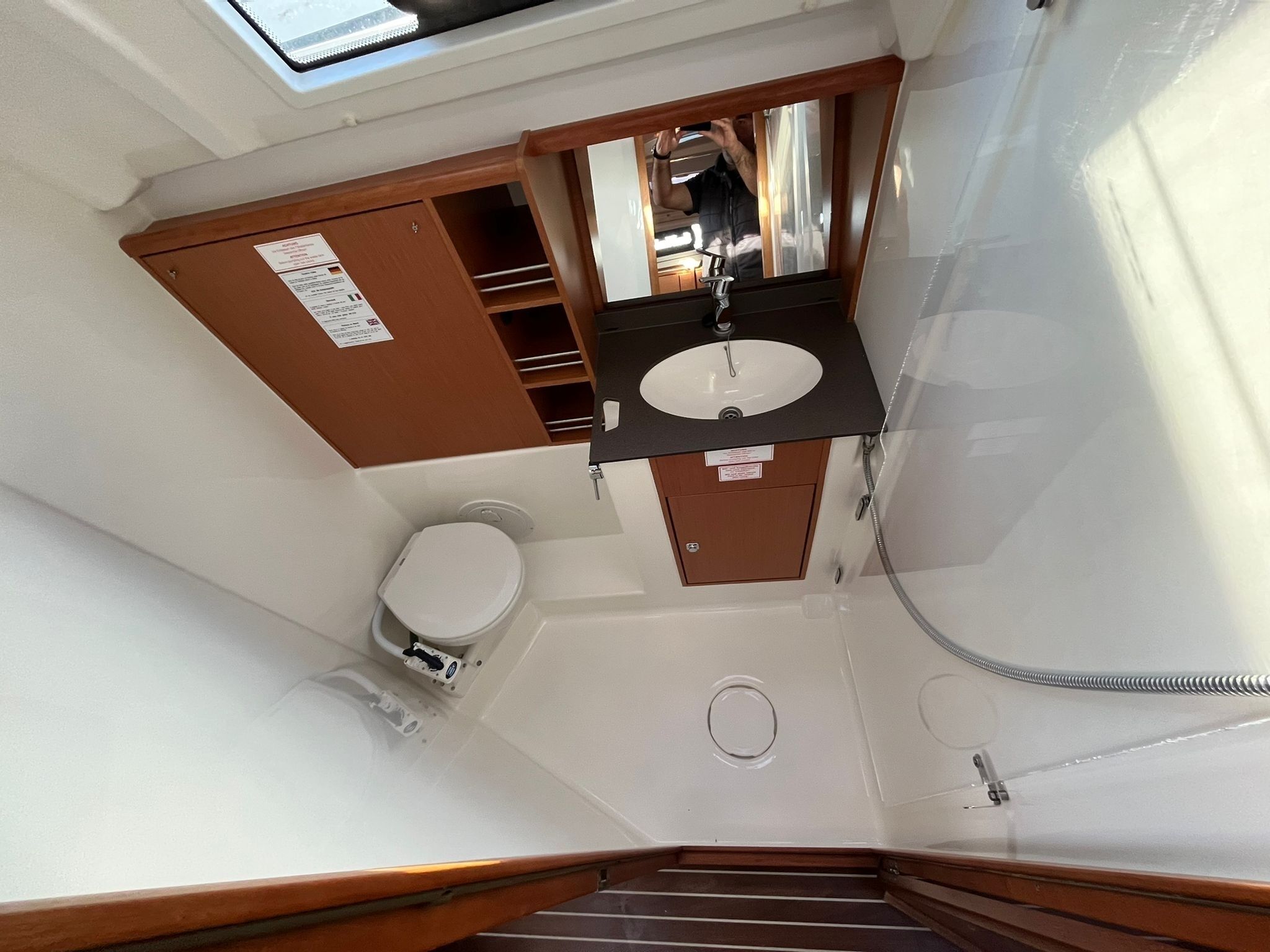 Een kleine badkamer met toilet, wastafel en douche.