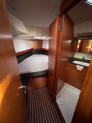 A compact, well-lit cabin with a small kitchenette, a single bed, and a storage cabinet. - Sun-Kissed Sailing Adventure in Zadar, Croatia (Bibinje)