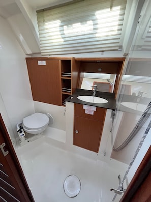 A compact bathroom with a toilet, sink, and shower. - Sun-Kissed Sailing Adventure in Zadar, Croatia (Bibinje)
