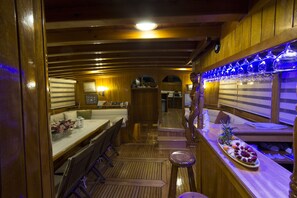 Un intérieur en bois comprenant un espace repas, un bar et une cuisine.