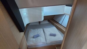 A compact cabin with a bed, a small seating area, and a wooden floor. - Sun-kissed Sailing Adventure in Split-Dalmatia, Croatia (Trogir)