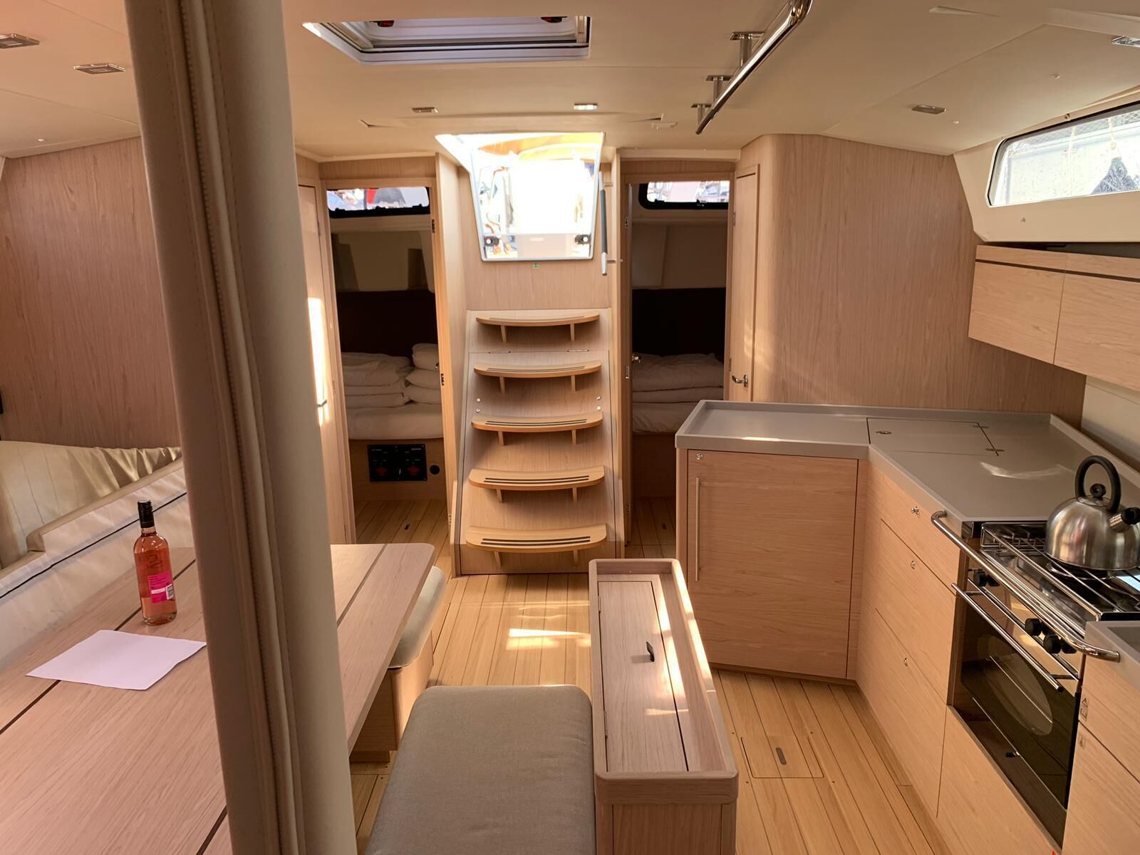 A compact RV interior with a kitchenette, a dining area, and a sleeping space.