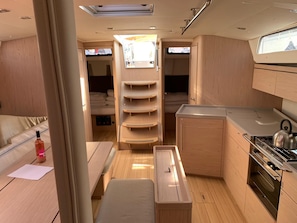 A compact RV interior with a kitchenette, a dining area, and a sleeping space. - Sun-Kissed Sailing Adventure in Zadar, Croatia (Bibinje)