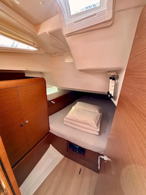 A compact cabin with a bed, a small cabinet, and a window. - Sun-Kissed Sailing Adventure in Zadar, Croatia (Bibinje)