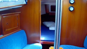 A compact interior with a bunk bed, a small table, and a bench. - Sun-kissed Sailing Adventure in Split-Dalmatia, Croatia (Trogir)