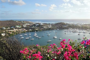 A coastal town with a marina filled with sailboats, surrounded by hills and residential buildings. - Caribbean Sun and Beach Sailing Adventure from San Martín (Saint Martin)