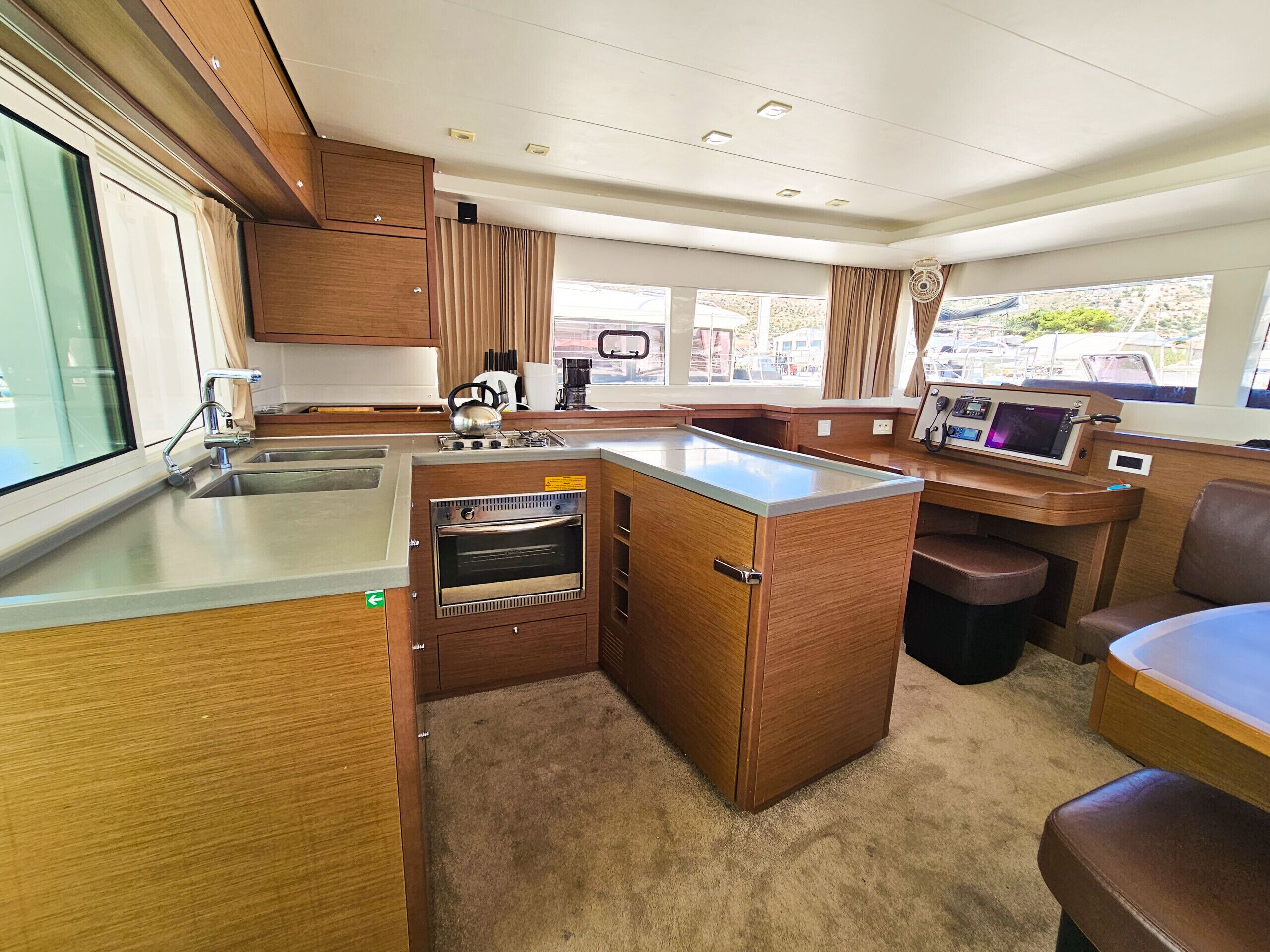 A compact kitchen with a built-in oven, a sink, and a small dining area with a bench.